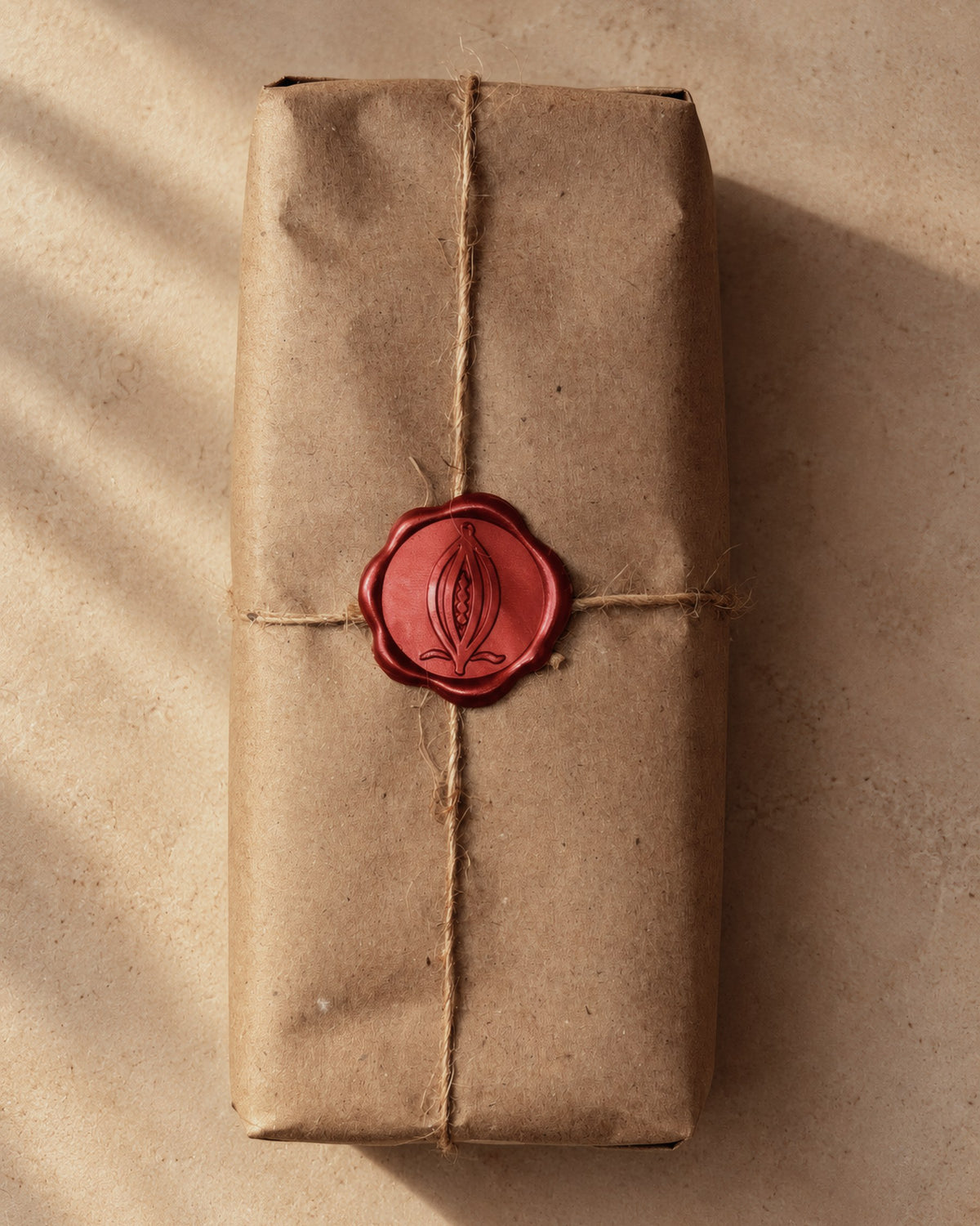 An ALPAKA cacao block wrapped in kraft paper and twine, closed with a red wax seal