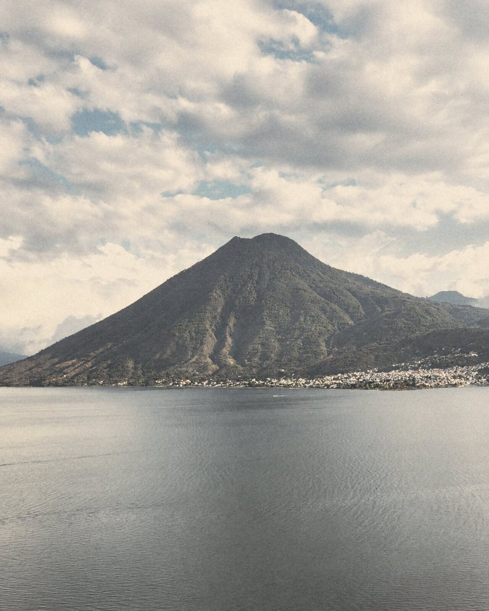 Lake Atitlán and one of its volcanoes under a cloudy sky